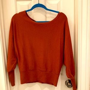 Anthropologie rust colored boat neck with billowy sleeves.
